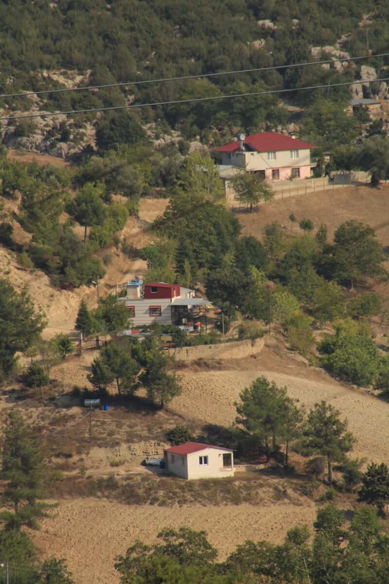 A picturesque alpine house nestled in Bolu's lush green mountains, under a clear blue sky.